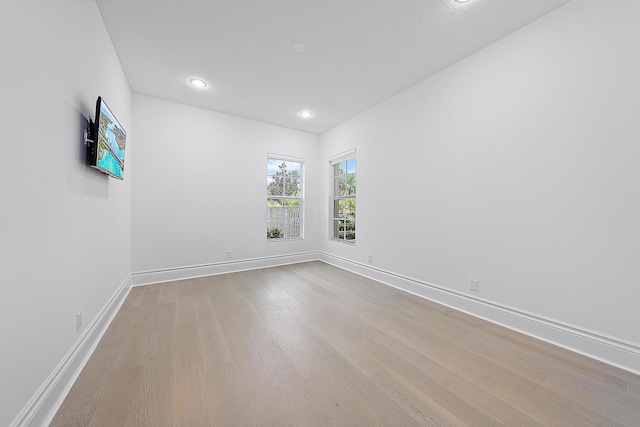 empty room with recessed lighting, baseboards, and wood finished floors