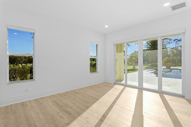 spare room with recessed lighting, wood finished floors, visible vents, and baseboards