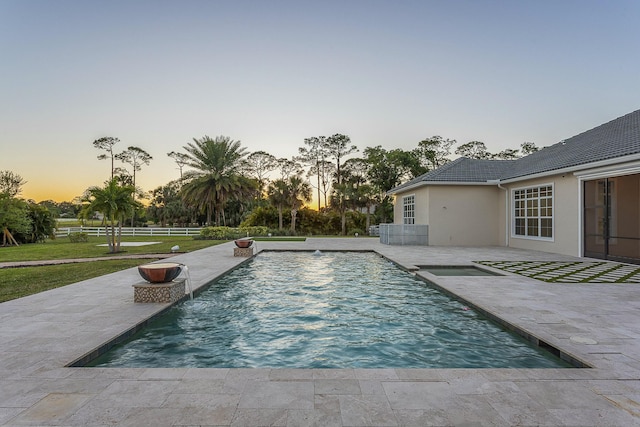 pool featuring a patio, fence, and a lawn