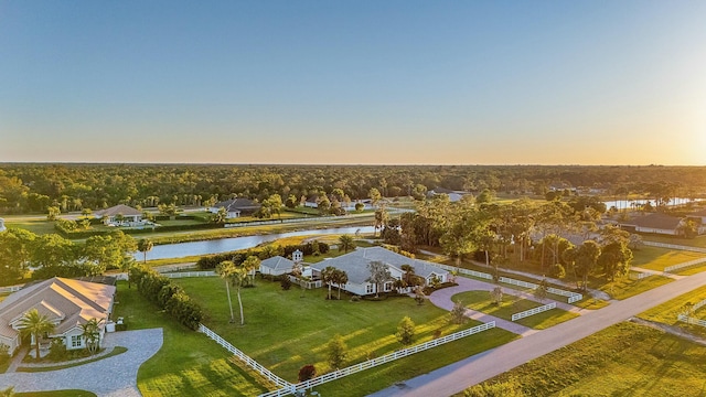 aerial view at dusk featuring a water view