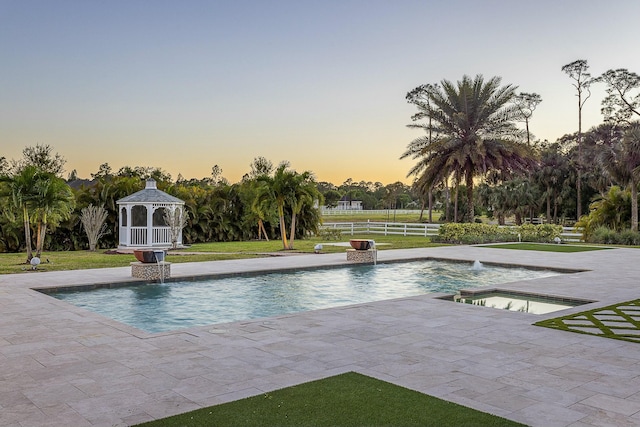 outdoor pool featuring a gazebo, an in ground hot tub, a yard, and fence