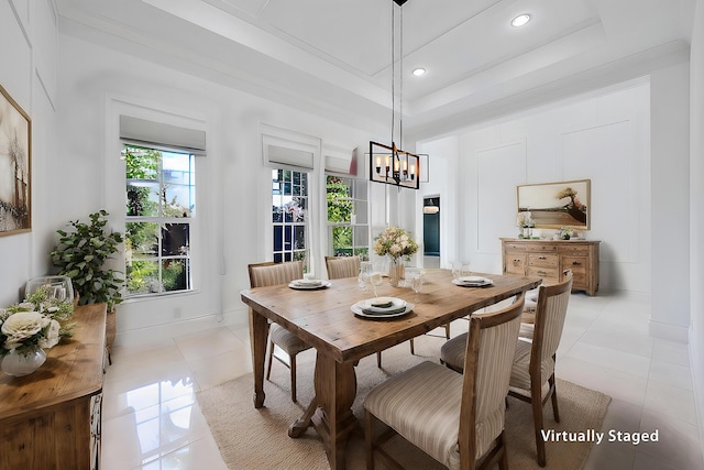 dining room featuring a notable chandelier, a tray ceiling, plenty of natural light, and light tile patterned floors