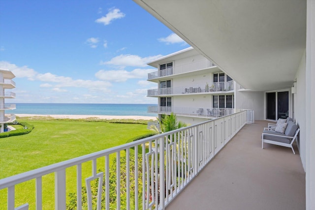 balcony featuring a beach view and a water view