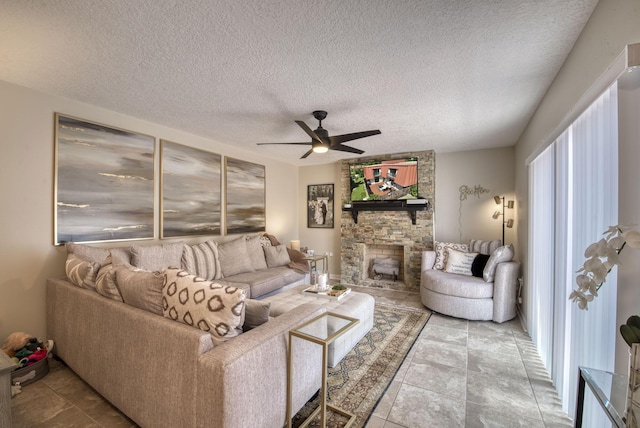 living area with ceiling fan, a fireplace, and a textured ceiling