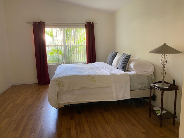 bedroom with lofted ceiling and wood-type flooring