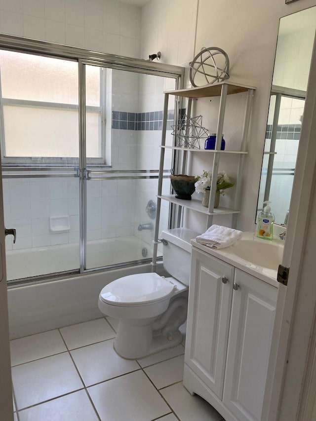 full bathroom featuring vanity, combined bath / shower with glass door, toilet, and tile patterned floors