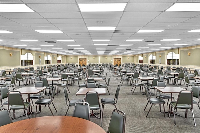 carpeted dining room with a paneled ceiling