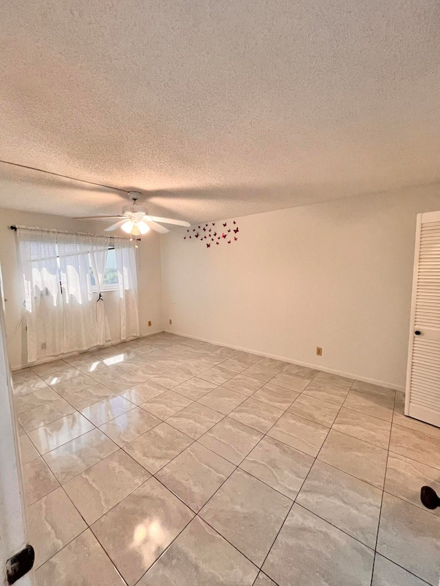 spare room featuring a textured ceiling and ceiling fan