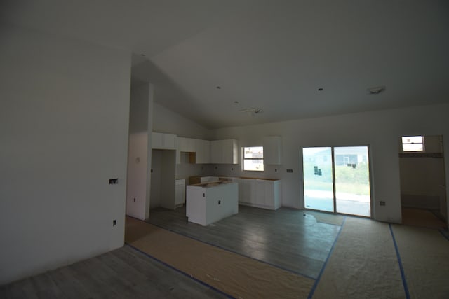 kitchen featuring a center island, hardwood / wood-style flooring, high vaulted ceiling, and white cabinetry