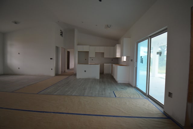 kitchen featuring vaulted ceiling, white cabinetry, and a center island