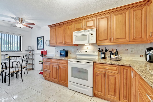 kitchen featuring a textured ceiling, white appliances, tasteful backsplash, ceiling fan, and light stone counters