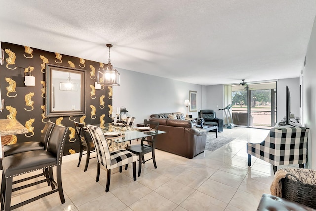 tiled dining space with a textured ceiling and ceiling fan