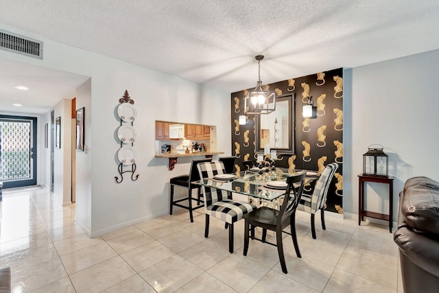 tiled dining room featuring a textured ceiling and an inviting chandelier