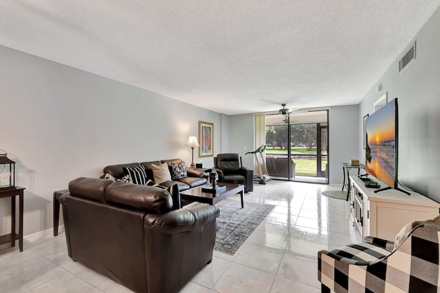 living room featuring a textured ceiling, ceiling fan, and light tile patterned floors