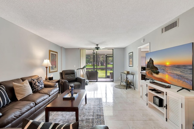 living room with a textured ceiling and ceiling fan