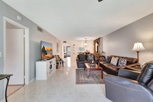 living room featuring a textured ceiling and light tile patterned flooring