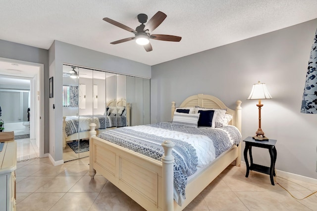 tiled bedroom with a textured ceiling, ceiling fan, and a closet