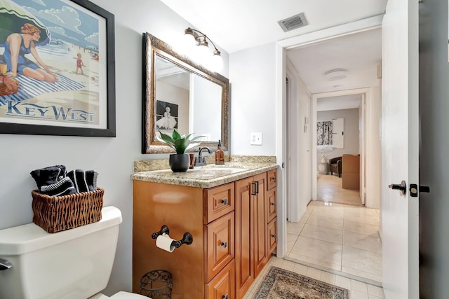 bathroom featuring tile patterned flooring, toilet, and vanity