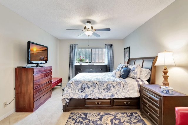 bedroom featuring a textured ceiling, ceiling fan, and light tile patterned floors