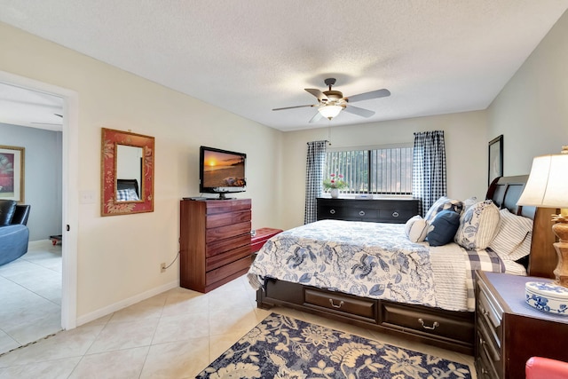 tiled bedroom with ceiling fan and a textured ceiling