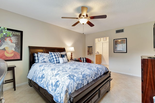 bedroom featuring a textured ceiling, ceiling fan, and light tile patterned floors