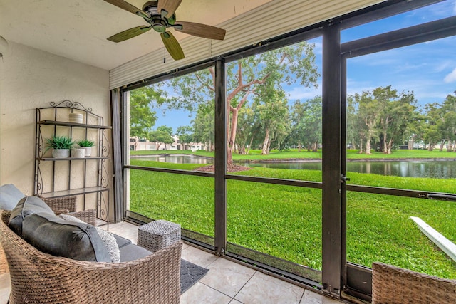 sunroom featuring a water view, ceiling fan, and a wealth of natural light