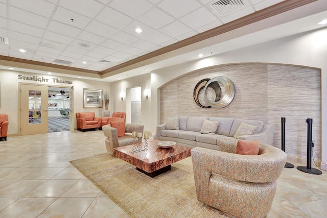 living room with ornamental molding, light tile patterned floors, a tray ceiling, and a drop ceiling