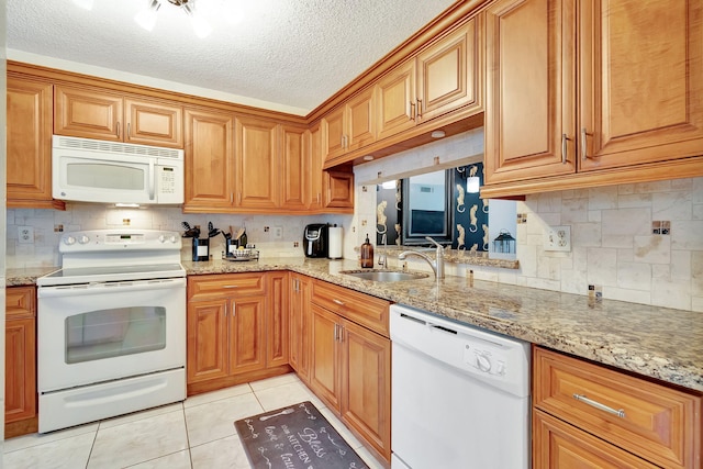 kitchen featuring a textured ceiling, sink, white appliances, and tasteful backsplash