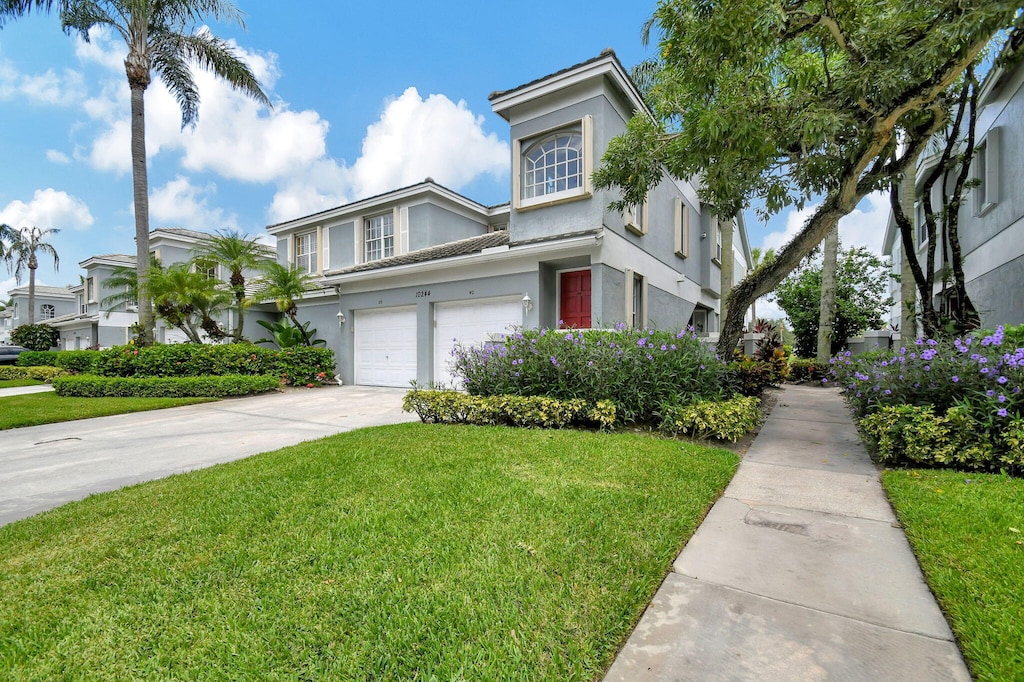 view of front of home with a garage and a front lawn