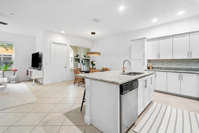 kitchen featuring backsplash, sink, stainless steel dishwasher, white cabinetry, and light stone counters