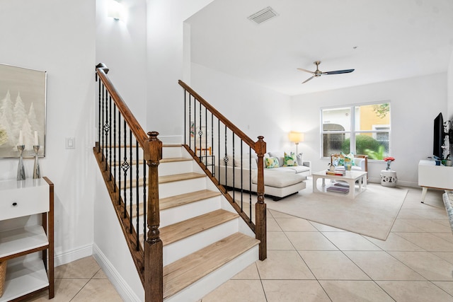 staircase with ceiling fan and tile patterned floors