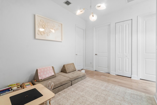 living room with a chandelier and light wood-type flooring