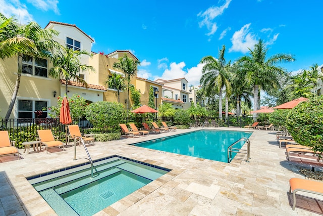 view of swimming pool with a patio area and a hot tub