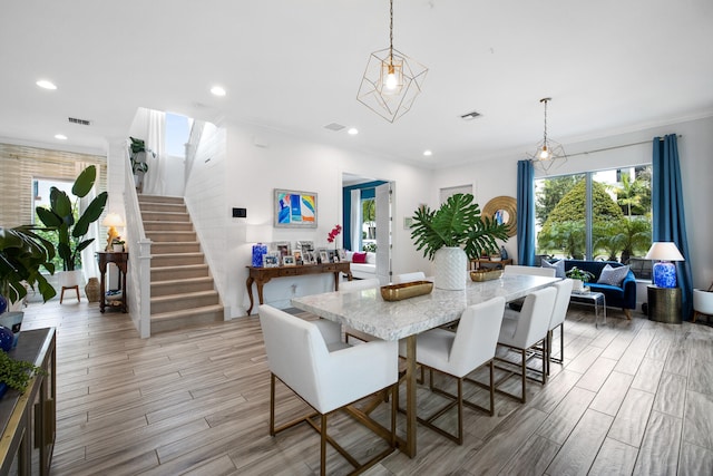 dining room with crown molding and light hardwood / wood-style floors