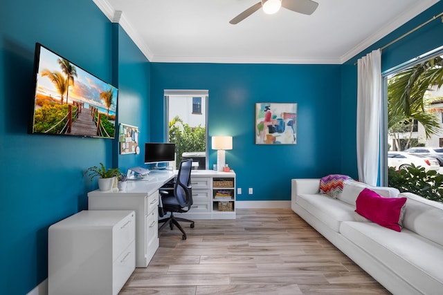 office space with ceiling fan, light hardwood / wood-style floors, a healthy amount of sunlight, and crown molding