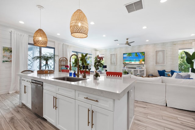 kitchen with stainless steel dishwasher, plenty of natural light, pendant lighting, and white cabinets