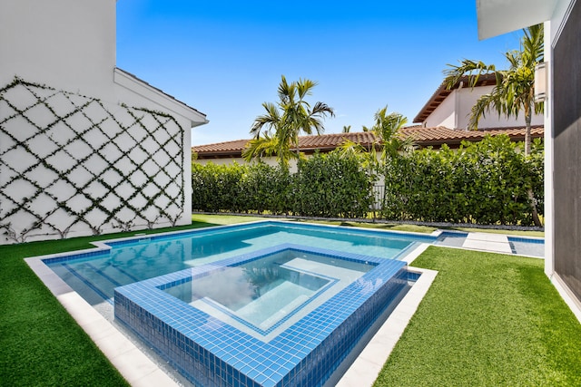 view of swimming pool with a lawn and an in ground hot tub