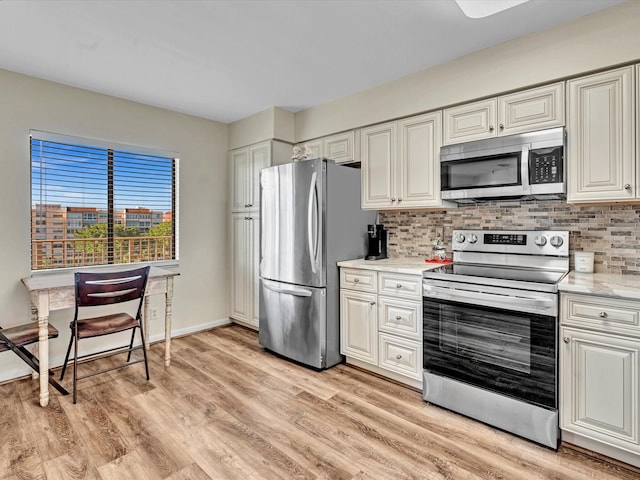 kitchen featuring decorative backsplash, light stone countertops, stainless steel appliances, and light hardwood / wood-style floors