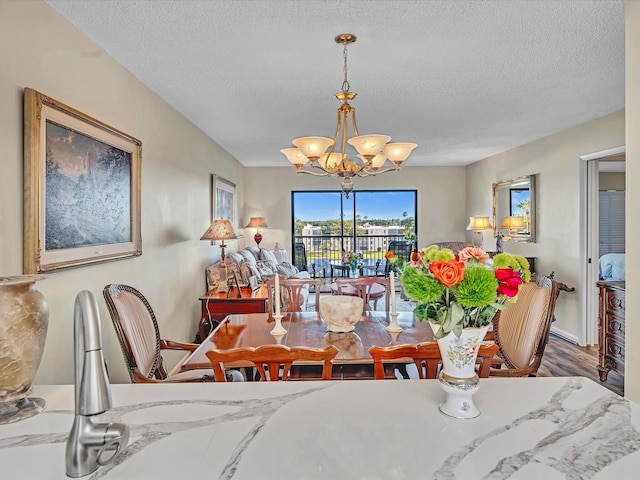 dining room with a notable chandelier, hardwood / wood-style floors, and a textured ceiling