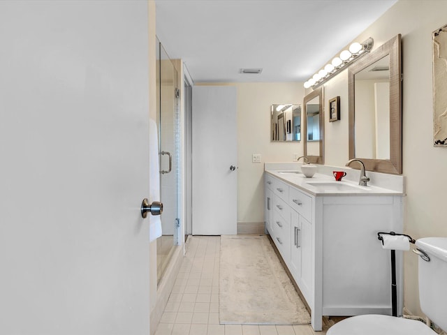 bathroom featuring vanity, toilet, tile patterned floors, and a shower with door