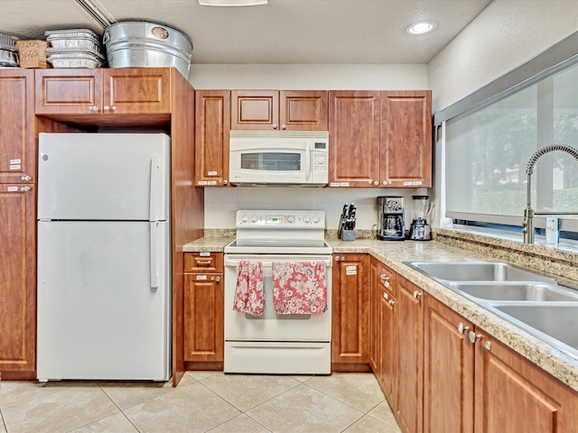 kitchen with white appliances, light tile patterned floors, and sink