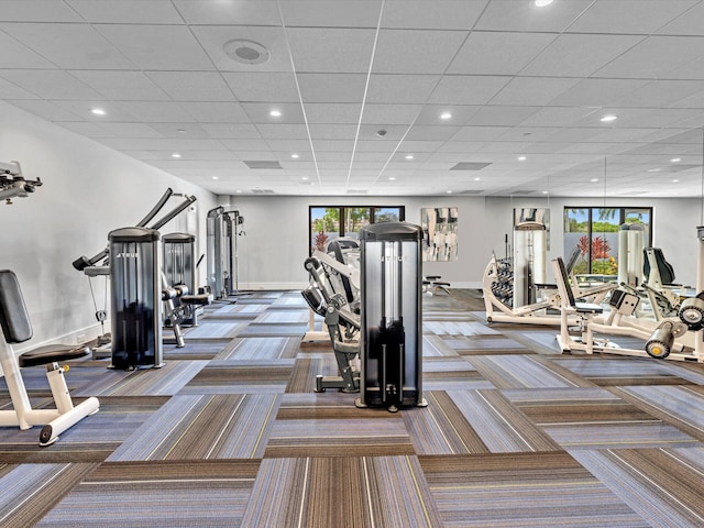 workout area with a paneled ceiling and carpet