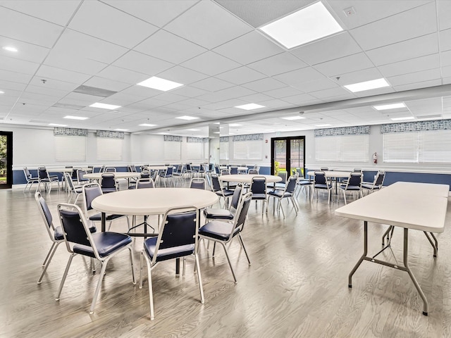 dining space featuring light hardwood / wood-style flooring and a paneled ceiling