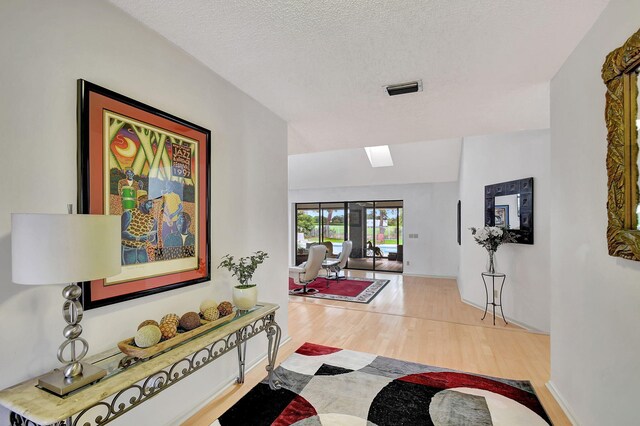 hall featuring hardwood / wood-style floors and a textured ceiling