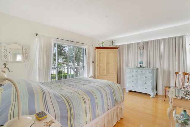 bedroom with access to exterior and light wood-type flooring