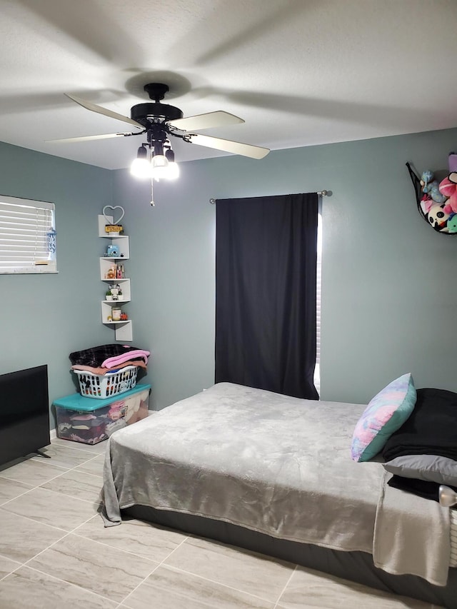 tiled bedroom featuring ceiling fan