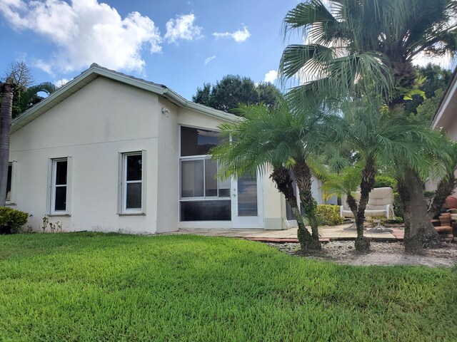 back of house with a yard and a patio area