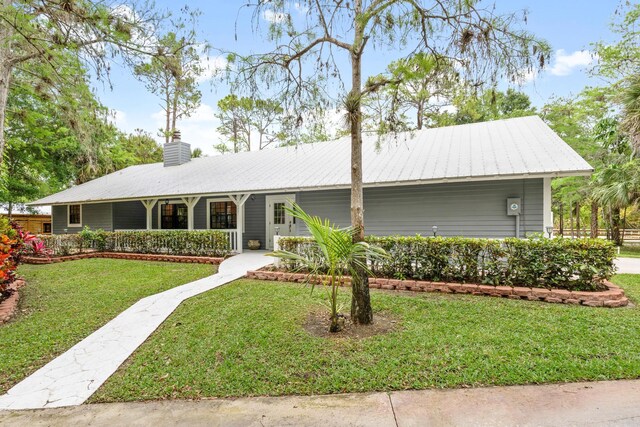 ranch-style house featuring covered porch and a front yard