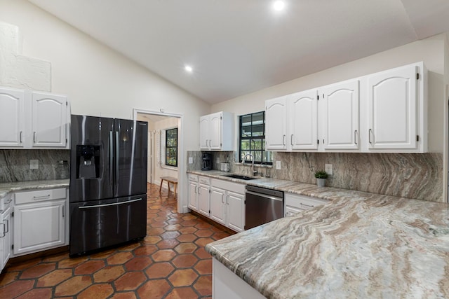 kitchen featuring black refrigerator with ice dispenser, dishwasher, sink, decorative backsplash, and lofted ceiling