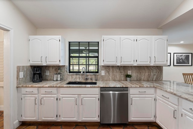 kitchen featuring white cabinetry, light stone counters, sink, decorative backsplash, and stainless steel dishwasher